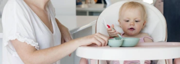 Mother feeding her little baby at home